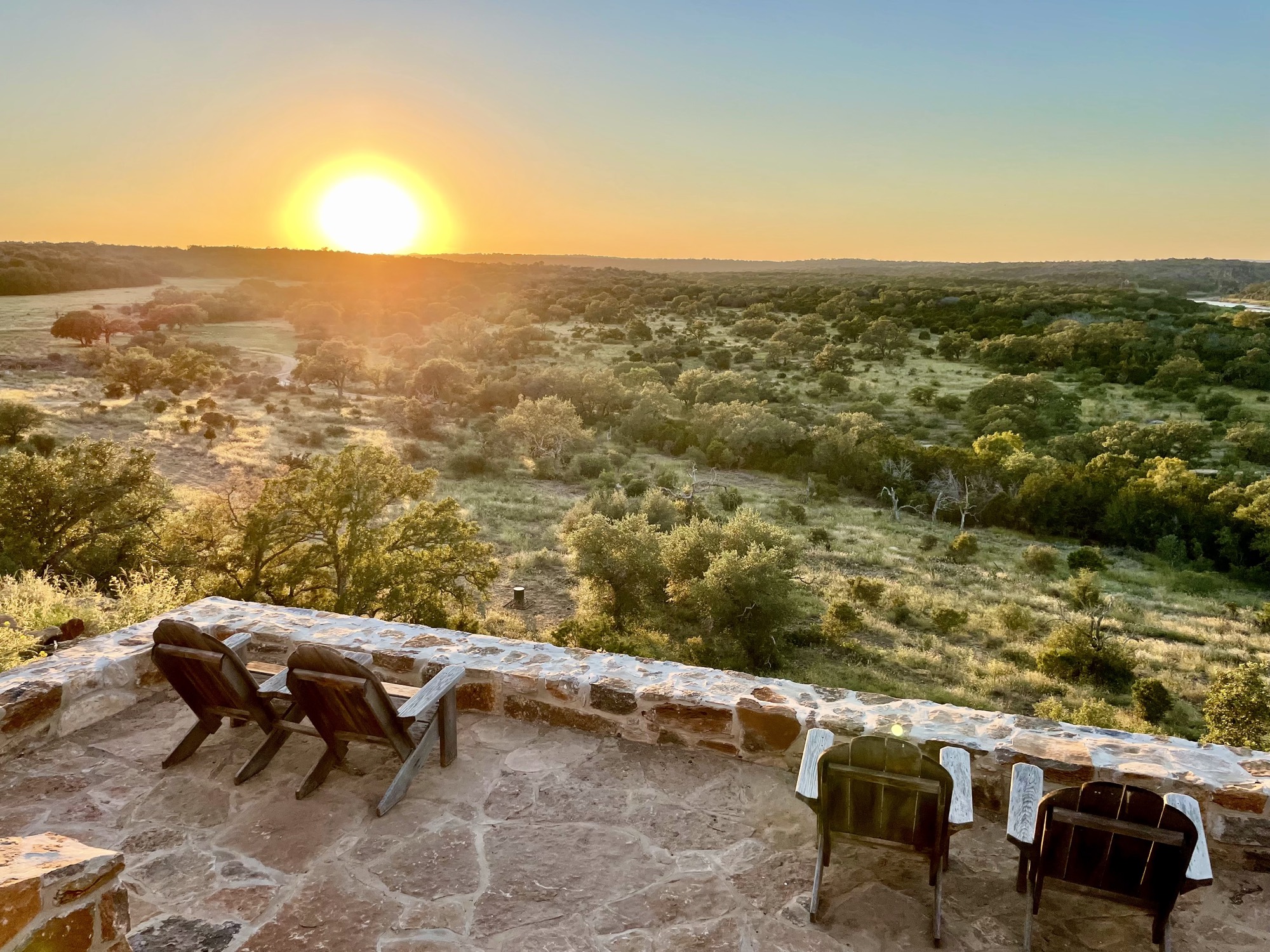 High ridge lookout with rolling Hill Country falling away to the horizon at sunset.